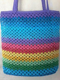 a multicolored crocheted bag hanging on a wall