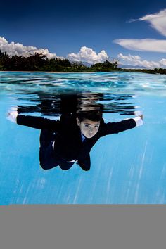 a young boy is swimming in the water with his head above the water's surface