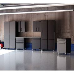 an empty garage with several cabinets and a car parked in front of the wall behind it