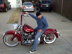 a man sitting on top of a red motorcycle