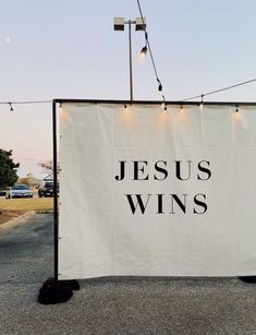 a white banner with jesus wins written on it