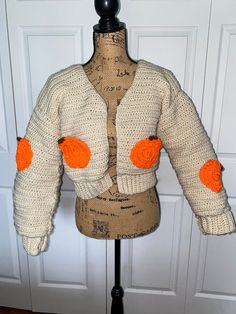 a mannequin wearing a sweater with orange pom - poms on it