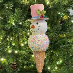 an ice cream cone ornament with a snowman wearing a pink top hat