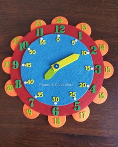 a clock made out of felt with numbers on the face and around it's sides