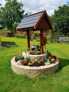 a wooden gazebo sitting on top of a lush green field