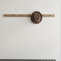 a hat is hanging on the wall next to a coat rack with hooks in it