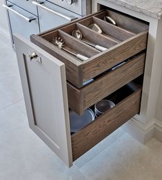 an open drawer in the middle of a kitchen