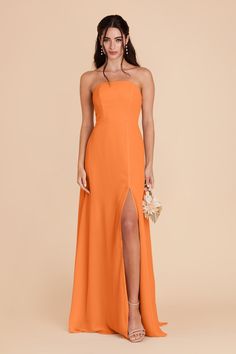 a woman in an orange strapless bridesmaid dress with high slit and side slit