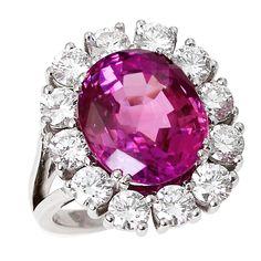 A beautiful and vibrant 10+ carat oval pink sapphire accented with a cluster of twelve round brilliant cut diamonds weighing approximately three carats, with (H/I color, VS-SI clarity), set in 18kt white gold. The pink sapphire displays exceptional clarity, measures excellent proportions of 13 x 11 x 7 mm, and accompanies a gemological report from AGL stating the origin as Ceylon (Sri Lanka) with indications of low temperature heating and no clarity enhancement. Pink Sapphire Rings, Pink Sapphire Jewelry, Vintage Cluster Ring, Pink Diamonds, Cluster Rings, Pink Bling, Expensive Jewelry, Pink Jewelry, Earrings Pink