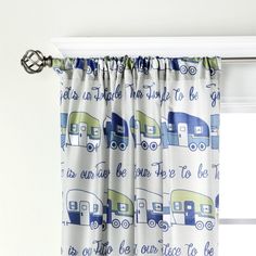 a curtain with blue and green campers on it, hanging from the side of a window