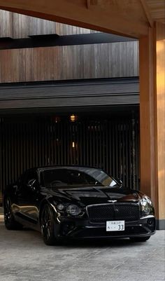 a black sports car parked in front of a garage