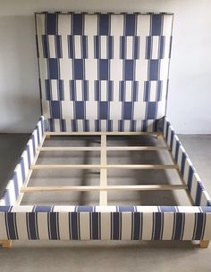 an upholstered bed frame with blue and white stripes