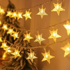 christmas lights are hanging on the wall next to a tree