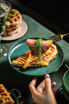 a person is holding a plate with food on it and there are other plates in the background