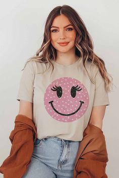 Wink Smiley Face Graphic T-Shirt. Designed for comfort and style. 100% Premium Cotton Unisex Sizing Classic Fit Pink Short Sleeve T-shirt With Smiley Face, Pink Cotton T-shirt With Smiley Face, Trendy Short Sleeve T-shirt With Smiley Face, Casual Smiley Face T-shirt, Smiley Face Graphic, Spring Smiley Face Short Sleeve T-shirt, Face Graphic, Light Peach, Smiley Face