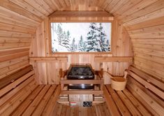 the inside of a wooden sauna with an open window and stove top in it