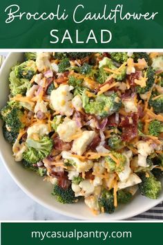 a bowl filled with broccoli and cheese on top of a marble countertop