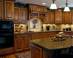 a large kitchen with wooden cabinets and granite counter tops, along with an island in the middle