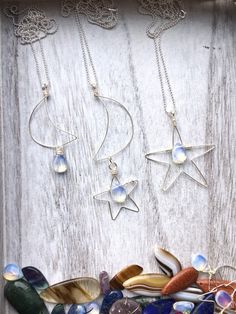 "These unique hand shaped moon and star necklaces are a totally original design and a one-of-a-kind must-have for the celestial lover. A glowing teardrop opalite accents each pendant. Each handmade pendant comes on a 28\" sterling silver ball chain. I carefully shape each pendant by hand from tarnish-resistant silver wire. These are super lightweight and hang beautifully. Please select the necklace you would like from the drop down menu. Pendant lengths: Star measures 2.5\" Moon measures 2.75\" Star Necklaces, Handmade Wire Wrapped, Moon And Star, Hand Shapes, Faceted Crystal, Moon Necklace, Handmade Pendant, Polish Jewelry, Star Necklace