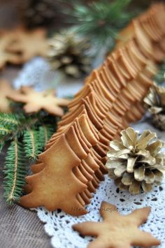 some cookies and pine cones on a doily