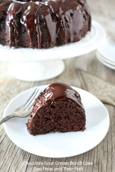 a chocolate bundt cake on a white plate with a bite taken out of it