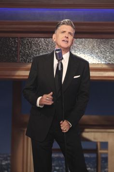 a man in a suit and tie holding a microphone