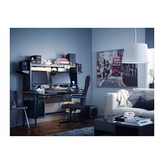 a living room filled with furniture and a computer desk in front of a blue wall