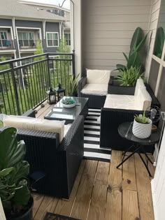 a balcony with black wicker furniture and potted plants