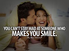 a man and woman laying in bed with the caption you can't stay mad at someone who makes you smile