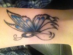 a blue butterfly tattoo on the ankle with black and white ink, it looks like an artistic