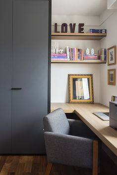 a desk with a chair and bookshelf in front of it, next to a large bookcase