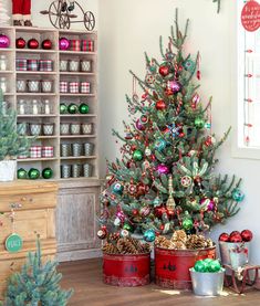 a small christmas tree in a room with other ornaments on the floor and around it