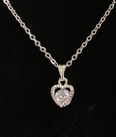 "This cute little heart necklace features a floating, round cubic zirconia in a silver plated alloy setting with a sterling silver bail (the piece that the pendant hangs from) and a dainty hypoallergenic stainless steel chain.  Perfect to wear every day with jeans, business attire, or formalwear.  Also a great idea for bridal parties, wonderful for Valentine's Day, Mother's Day, or any day you're feeling the love!  You'll love the sparkle as the stone dangles and floats in the setting. Total len Elegant Silver Heart Cut Charm Necklace, Silver Heart Cut Necklace For Party, Silver Heart Necklace With Delicate Chain And Round Pendant, Silver Heart Necklace With Cubic Zirconia, Silver Cubic Zirconia Round Heart Necklace, Silver Cubic Zirconia Heart Necklace, Dainty Silver Heart Necklace For Formal Occasions, Silver Cubic Zirconia Heart Necklace With Heart Charm, Silver Heart Necklace With Delicate Chain