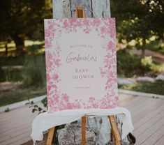 a welcome sign for a baby shower on an easel in front of a tree