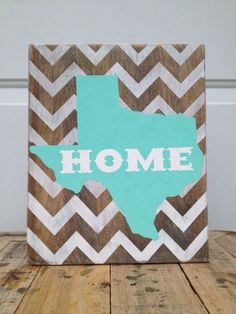 a wooden sign with the word home painted on it in blue and brown chevrons