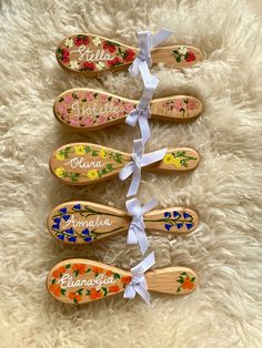 five wooden shoes with flowers and names tied to them on a white furnishing