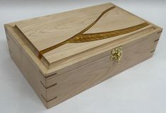 an empty wooden box with gold decoration on the lid