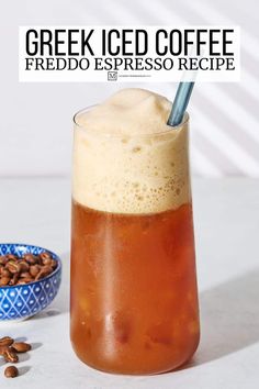 a glass filled with iced coffee next to a bowl of nuts