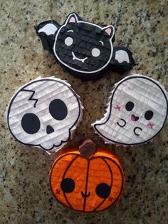 three paper plates decorated with halloween decorations on a counter top, one has a cat and the other has a pumpkin