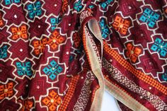 Phulkari refers to the folk embroidery of the Punjab. Although phulkari means floral work, the design include not only flowers but also covers motifs and geometrical shapes. The craft of phulkari has undergone changes over the centuries. This gorgeous colorful phulkari on pure chinnon in burgundy base color is so versatile and can be worn as a dupata, scarf or on any wedding occasion. Our phulkaris are handcrafted to perfection keeping in mind the authenticity of the culture in an urban way. Sta Traditional Multicolor Bandhani Print Traditional Wear, Folk Style Cotton Embroidered Dupatta, Embroidered Cotton Folk Dupatta, Navratri Traditional Wear With Bandhani Print And Multicolor Embroidery, Folk Style Embroidered Cotton Dupatta, Traditional Wear With Multicolor Bandhani Print For Diwali, Bohemian Red Traditional Wear With Bandhani Print, Red Bohemian Traditional Wear With Bandhani Print, Traditional Multicolor Embroidered Cotton Fabric