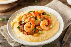 a white plate topped with grits and shrimp