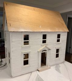 a model house is on display in a room with white walls and wood trimmings