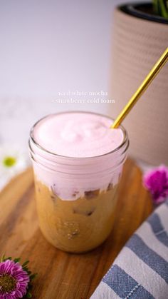 a jar filled with food sitting on top of a wooden cutting board next to flowers