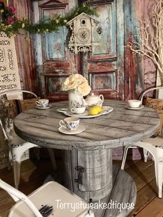 a round table with chairs around it in front of a wall painted with old doors