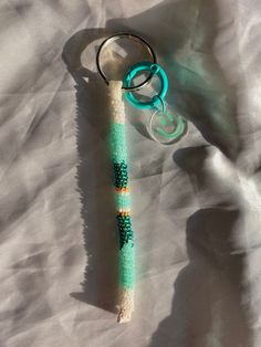 a keychain is laying on top of a piece of paper with beads attached to it