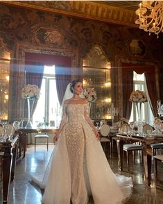 a woman in a wedding dress standing next to a table