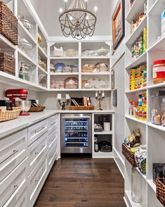 an organized pantry with white cabinets and shelves