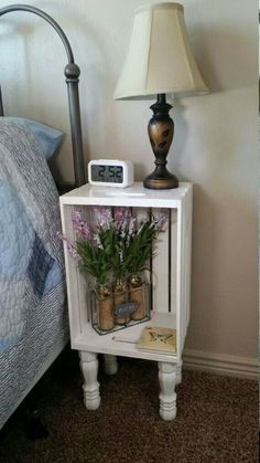 a nightstand with flowers and a clock on it