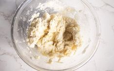 a glass bowl filled with flour on top of a white counter