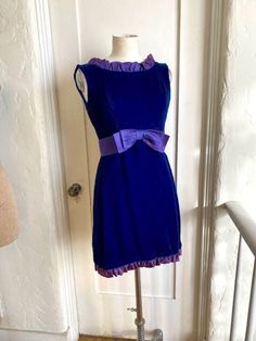 This is an adorable vintage 1960'd blue velvet sleeveless, empire waist mini dress with a purple satin bow and ruffled trim. Full zip back.  The only label is a Union Made ILGWU one. In very good condition. There is no size tag, but I would guess a size small. Measurements are Underarm to underarm - 16 " Under bust / Waist - 14" Shoulder to hem 34" 1960s Dresses Formal, 1960s Fashion Dress, Mimi Dress, Vintage Dress Blue, Vintage Velvet Dress, 1960s Dresses, Mood Clothes, Cocktail Dress Vintage, Purple Satin